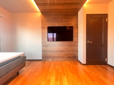 ～寝室の改修後の様子～
リアル木パネルを天井から壁とL型に見せ、壁掛けTVを設置しました。壁は布クロスを使用する事で温かみのあるホテルの一部屋の空間に生まれ変わりました。